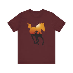 
                  
                    Load image into Gallery viewer, Flat lay mockup of a rust colored tee featuring the silhouette of a horse containing a red and yellow sunrise with the shadow of a cross against the horizon.
                  
                