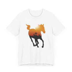 
                  
                    Load image into Gallery viewer, Flat Lay Mockup of a white tee shirt featuring the silhouette of a running horse containing a yellow and red sunrise and the shadow of a cross on the horizon
                  
                