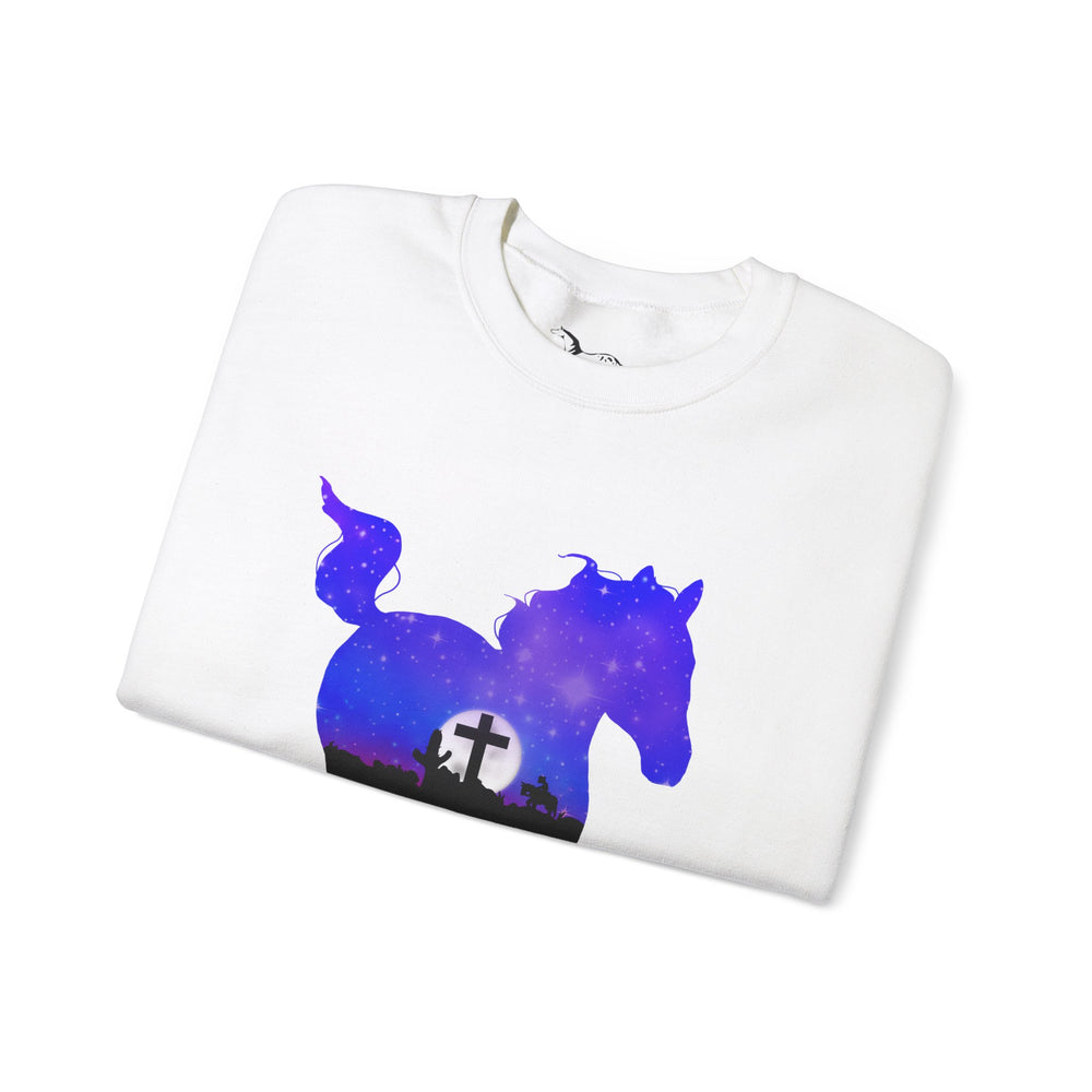 
                  
                    Load image into Gallery viewer, Mockup of a white crewneck sweater folded featuring a silhouette of a horse with a starry purple and blue night, a full moon on the horizon, and a cross against the full moon in the silhouette
                  
                